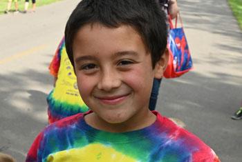 A Miles 4 Mentors Fun Run Participant Smiles After Race in New T-Shirt Give